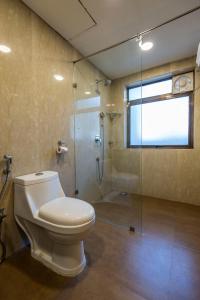 浦那Hotel Phoenix Koregaon Park的一间带卫生间和玻璃淋浴间的浴室
