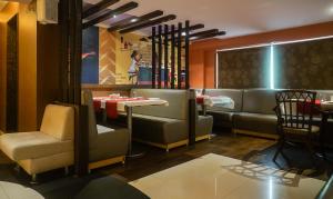 浦那Treebo Trend Brahma Regency的一间设有桌椅和女服务员的餐厅