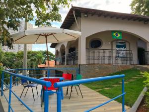 皮拉西卡巴Lodge Hostel Piracicaba的房屋前的游乐场,配有遮阳伞