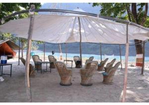 ShivpuriUbud Riverside Camps的海滩帐篷下的一组桌椅
