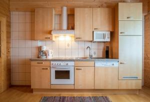 大格洛克纳山麓卡尔斯Haus Panoramablick的厨房配有木制橱柜和白色冰箱。