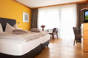 阿罗萨红和长廊酒店的一间设有两张床的卧室,位于拥有黄色墙壁的房间