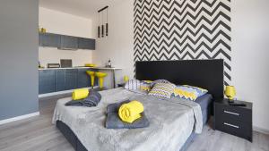 DębnoApartament Perła Pienin的一间卧室配有一张大床,提供黄色和蓝色的枕头