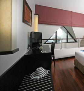 帕皮提大溪地酒店的客房设有一张桌子、一台电视和一张床