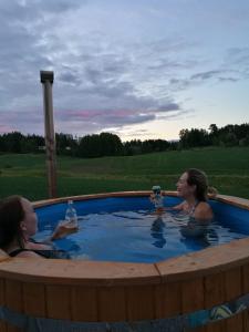 LaukkoskiWilla Mustijoki的两名女性坐在热水浴池中,享用饮品