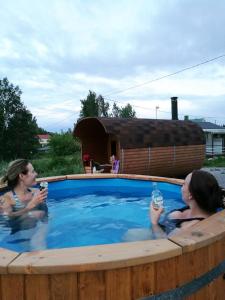 LaukkoskiWilla Mustijoki的两个女人在热水浴缸中喝啤酒