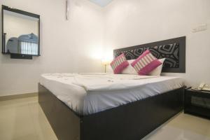 福拉杜岛阿佐什旅游宾馆的卧室配有一张带粉红色枕头的大床