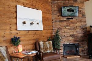 西黄石Elkhorn Cabins and Inn的客厅设有壁炉,并展示了动物的照片