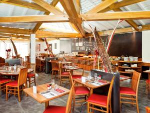 布隆里昂东布隆宜必思酒店的一间带木桌椅的餐厅和一间酒吧