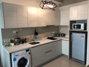 莎阿南[SLEEP 5PAX] Natural Living (i-Soho, i-City)的厨房配有洗衣机和洗碗机。