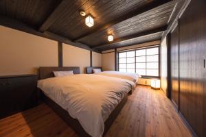 汤浅町纪州汤浅古民家町屋宿泊千山庵度假屋的一间卧室设有一张大床和一个窗户。