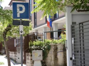 坎波巴索casa vacanze luciano&son的标志在有旗帜的建筑前的停车标志