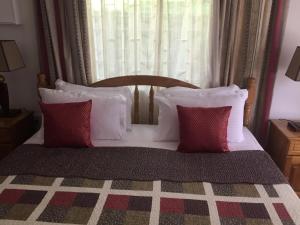 维多利亚Mountain Top Chalet的一张带红色和白色枕头的床和窗户
