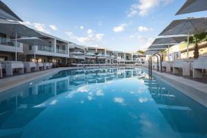 阿尔米里达Aloe Boutique Hotel & Suites - adults only的酒店旁的游泳池配有椅子和遮阳伞