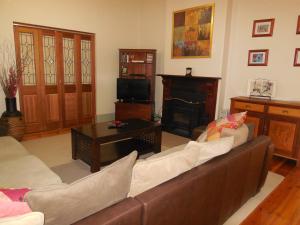 WaikerieAmalie Cottage Waikerie Unit 1的带沙发和壁炉的客厅