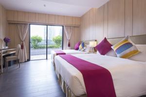 香港挪亚方舟度假酒店的酒店客房设有两张床、一张桌子和一张书桌。