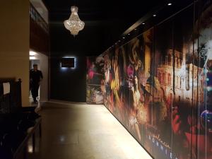 瓦伦西亚BONNIES Suites & Spa Valencia的走下走廊,墙上挂着绘画的人