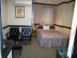 川口市Nishikawaguchi Station Hotel Stay Lounge的配有一张床和一把椅子的酒店客房