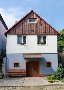 DrnholecSklep u Malíků的蓝色和白色的房子,有棕色的屋顶