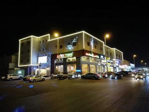 吉达Farha International Residential Units的一座有汽车在晚上停在停车场的建筑