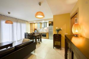 莱斯普卢加德夫兰科利卡拉伯乐塔公寓式酒店的客厅以及带沙发和桌子的厨房。