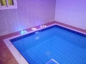 艾卜哈Al Worod Al Thahabia Chalets的客房内设有一个蓝色瓷砖的大型游泳池