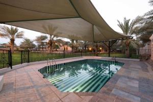 欧奈宰阿纳奇度假酒店的庭院内一个带遮阳伞的游泳池