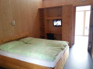 FrascoFamilienhotel Campagna的木制卧室配有床和电视