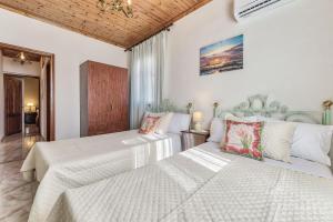 Agios LeonSempreviva的配有白色墙壁的酒店客房内的两张床
