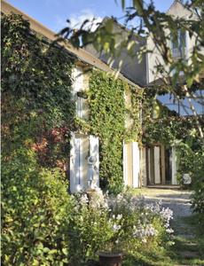 韦兹莱康波斯特拉酒店的常春藤覆盖的房子,前面有一个花园