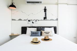 奈扬海滩Dwell Phuket Airport Hotel at Naiyang的一间卧室,配有一张带两顶帽子的床