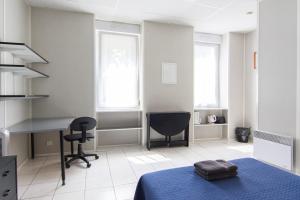 马赛及时行乐公寓式酒店的一间卧室配有一张床、一张桌子和一把椅子