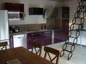 圣艾格夫Villa Némausa / Saint-Aygulf的厨房配有紫色橱柜和桌椅