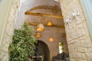 阿尔贝罗贝洛Hermanas Relais - trulli luxury的客厅设有石墙和沙发。
