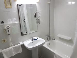 罗列特海岸诺莱酒店的白色的浴室设有水槽和浴缸。