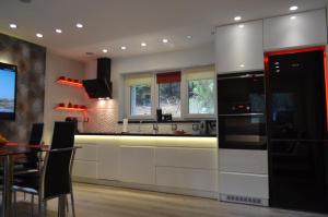 克雷尼察Luzik Krynica的厨房配有白色橱柜和黑色冰箱。