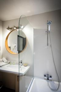 勒格罗-迪鲁瓦Oustau Camarguen Hôtel & Spa的带淋浴、盥洗盆和镜子的浴室