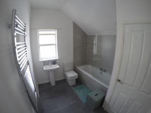 斯图尔特港Portstewart Holiday Home的一间带水槽和卫生间的浴室以及窗户。