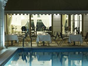 斯巴达莫内莱恩酒店的游泳池旁设有桌椅