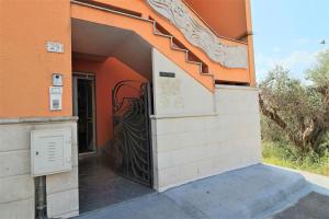 马蒂诺Sol Salento的一座橙色建筑的入口,有黑色的大门