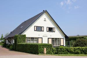 OosterhoutB&B Buitenwaard的黑色屋顶的白色房子