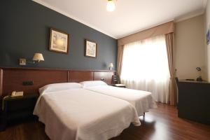 卡拉米尼亚尔镇霍斯佩达科斯维拉旅馆的一间卧室设有两张白色的床和窗户