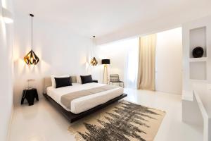 帕罗奇亚Paros Agnanti Resort & Spa的一间白色卧室,配有床和地毯