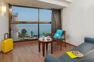 提比里亚太巴列莱昂纳多酒店的带沙发、桌子和窗户的客厅