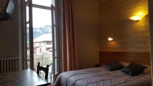 拉尔让蒂埃拉贝塞埃Hôtel Restaurant Glaizette的一间卧室设有一张床和一个大窗户