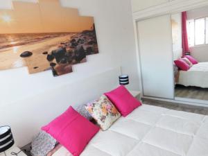 阿罗纳Rosamar Luxury Apartment的客厅配有带粉红色枕头的白色沙发