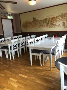 图什比比奥尼德特酒店的用餐室配有白色的桌子和白色的椅子