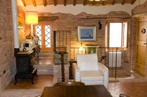 MontegiorgioB&B La Cappellania的客厅配有白色椅子和炉灶