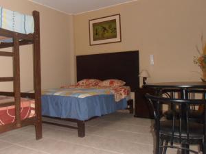 利马Septima Maravilla的一间卧室配有一张双层床和一张桌子