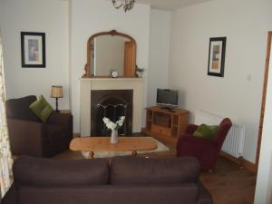 AirdAird Cottage的客厅配有沙发和桌子